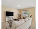 Bright living room featuring a TV, exercise bike, comfortable couch and tile flooring at 2416 White Poppy Dr, Kissimmee, FL 34747