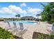 Community pool area with lounge chairs, palm trees, and a clubhouse at 2416 White Poppy Dr, Kissimmee, FL 34747