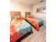 Cozy bedroom featuring two twin beds with orange and blue bedding and light wood flooring at 3014 Red Ginger Rd, Kissimmee, FL 34747