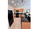 Functional kitchen featuring black appliances, granite countertops, and tile flooring at 3014 Red Ginger Rd, Kissimmee, FL 34747