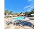 Community pool with lounge chairs surrounded by palm trees, creating a relaxing oasis for residents at 3014 Red Ginger Rd, Kissimmee, FL 34747