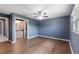 Bright bedroom boasts hardwood floors, blue accent wall and ensuite bathroom with natural light at 31 Lake Link Se Cir, Winter Haven, FL 33884