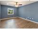 Bedroom with wood-look flooring, ceiling fan, and window offering natural light at 31 Lake Link Se Cir, Winter Haven, FL 33884