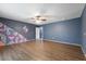 Large bedroom with hardwood floors and an accent wall with colorful geometric shapes at 31 Lake Link Se Cir, Winter Haven, FL 33884