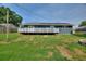 Back of the house with solar panels and a green lawn at 31 Lake Link Se Cir, Winter Haven, FL 33884