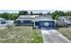 Exterior view of the house featuring solar panels, blue paint, landscaping and a driveway at 31 Lake Link Se Cir, Winter Haven, FL 33884