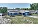 Exterior view of the house featuring solar panels, blue paint, landscaping and a driveway at 31 Lake Link Se Cir, Winter Haven, FL 33884