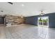 Bright living room with tile floors, a ceiling fan, and a wood-paneled accent wall at 31 Lake Link Se Cir, Winter Haven, FL 33884