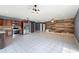Open living and kitchen space with stainless steel appliances and rustic wood-paneled wall at 31 Lake Link Se Cir, Winter Haven, FL 33884