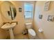 Cozy bathroom featuring a pedestal sink, toilet, window, and decorative wall art at 315 Wildflower Rd, Davenport, FL 33837