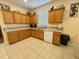 Bright kitchen with wooden cabinets, a window over the sink, and tiled floors for easy maintenance at 315 Wildflower Rd, Davenport, FL 33837