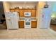 Well-lit kitchen featuring wooden cabinets, white appliances, and neutral countertops for a cozy cooking space at 315 Wildflower Rd, Davenport, FL 33837