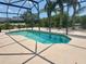 Sparkling pool surrounded by screened enclosure and lush landscaping, perfect for relaxing and entertaining at 315 Wildflower Rd, Davenport, FL 33837
