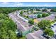 Aerial view of the colorful condominium complex with landscaping, trees, and pond at 3151 Britannia Blvd # C, Kissimmee, FL 34747