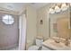Bright bathroom featuring tiled shower with curtain, toilet, and vanity sink at 3151 Britannia Blvd # C, Kissimmee, FL 34747