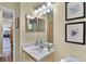 Powder room with updated vanity, wall decor, and a view into the living room at 3151 Britannia Blvd # C, Kissimmee, FL 34747