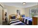 Cozy bedroom with two twin beds, striped bedding, side table, and a view to the outdoors at 3151 Britannia Blvd # C, Kissimmee, FL 34747