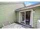 View from the outdoor patio into bedroom featuring a sliding glass door and striped bedding at 3151 Britannia Blvd # C, Kissimmee, FL 34747