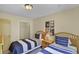 Inviting bedroom featuring two twin beds, striped bedding, a side table, and closet space at 3151 Britannia Blvd # C, Kissimmee, FL 34747