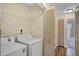 Convenient laundry room with washer, dryer, and storage space near a bathroom with tub and shower at 3151 Britannia Blvd # C, Kissimmee, FL 34747