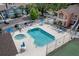 Aerial view of a community pool with lounge chairs, tables with umbrellas, and a hot tub for residents' enjoyment at 3151 Britannia Blvd # C, Kissimmee, FL 34747