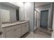 Bathroom features a double vanity with granite countertop, white cabinets, and a view of the glass-enclosed shower at 3442 Monaco Ln, Davenport, FL 33897