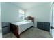 Cozy bedroom with wood-framed bed, carpeted floor, natural light, and mini fridge at 3442 Monaco Ln, Davenport, FL 33897