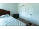 Bedroom showcasing a bed with patterned bedding, a small dresser, and a bright white closet at 3442 Monaco Ln, Davenport, FL 33897