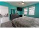 Bright bedroom with turquoise walls, plush carpet, ceiling fan, and a decorative dresser with mirror at 3442 Monaco Ln, Davenport, FL 33897