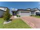 Attractive single-Gathering home with a well-maintained lawn and a brick driveway leading to a two-car garage at 3442 Monaco Ln, Davenport, FL 33897