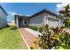 Charming single-story home featuring a gray exterior, a brick walkway, and manicured landscaping at 3442 Monaco Ln, Davenport, FL 33897