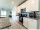 Modern kitchen featuring stainless steel appliances, white cabinets, and granite countertops with backsplash at 3442 Monaco Ln, Davenport, FL 33897