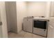 Bright laundry room features modern washer and dryer on light tile floor, plus a white door at 3442 Monaco Ln, Davenport, FL 33897