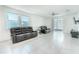 Bright living room with tile flooring, large windows, ceiling fan, and plush leather seating at 3442 Monaco Ln, Davenport, FL 33897