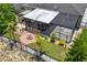 Aerial view of the backyard featuring a screened-in patio and cozy fire pit area at 3698 Cortland Dr, Davenport, FL 33837