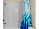 Bright bathroom featuring a tiled shower/tub combo and a vibrant sailboat-themed shower curtain at 3698 Cortland Dr, Davenport, FL 33837