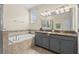 Bathroom featuring double sinks, granite counters, and a luxurious soaking tub at 3698 Cortland Dr, Davenport, FL 33837