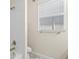Bathroom with white tile, bronze fixtures, and a toilet with a window above it at 3698 Cortland Dr, Davenport, FL 33837