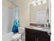 Well-lit bathroom featuring a shower/tub, toilet, dark cabinets, and granite counters at 3698 Cortland Dr, Davenport, FL 33837