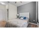 Cozy bedroom with a gray accent wall, stylish bed, and a glimpse into the bathroom at 3698 Cortland Dr, Davenport, FL 33837