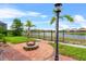 Scenic backyard fire pit area featuring a charming paver patio and serene water views, perfect for outdoor relaxation at 3698 Cortland Dr, Davenport, FL 33837