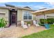 Inviting front patio with outdoor seating, stone accents, and lush landscaping at 3698 Cortland Dr, Davenport, FL 33837