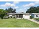 Charming one-story home with a well-maintained lawn, attached garage, and a screened-in porch, exuding curb appeal at 412 Georgia Ave, St Cloud, FL 34769