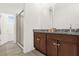 Bathroom featuring dual sinks, dark wood cabinets, granite countertops, and a glass shower at 4736 Homestead Trl, St Cloud, FL 34772