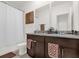 Bathroom featuring dual sinks, dark wood cabinets, and granite countertops at 4736 Homestead Trl, St Cloud, FL 34772