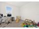Bright, carpeted bedroom featuring a desk, a window, and various toys at 4736 Homestead Trl, St Cloud, FL 34772
