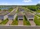 Overview of a residential community with modern homes, a nearby lake, and lush greenery at 4736 Homestead Trl, St Cloud, FL 34772