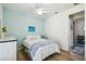 Bedroom featuring a bed with a white comforter, ceiling fan, and a blue accent wall at 582 San Joaquin Rd, Poinciana, FL 34759