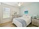 Bright bedroom featuring a bed with a white comforter, ceiling fan, and a blue accent wall at 582 San Joaquin Rd, Poinciana, FL 34759
