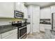 Modern kitchen featuring stainless steel appliances, granite countertops, and white cabinets at 582 San Joaquin Rd, Poinciana, FL 34759